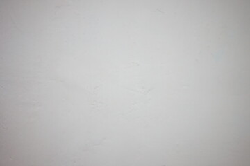 Plain white wall with subtle texture and soft lighting indoors