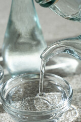 White distilled vinegar is poured into a glass vinegar bowl.