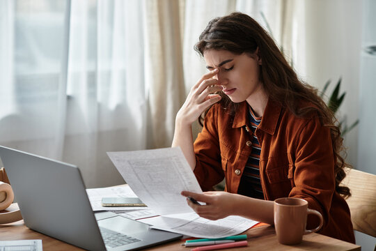 Overwhelmed woman struggling with depression while working from home in quiet surroundings