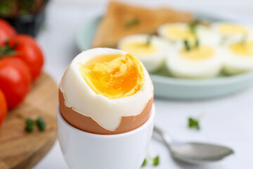 Soft boiled egg on white table, closeup