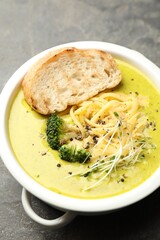 Delicious broccoli cream soup and crouton in bowl on gray textured table, above view