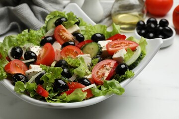 Delicious fresh Greek salad on white table, closeup