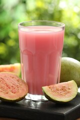 Refreshing guava juice and fresh fruits on wooden table, closeup