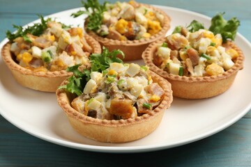 Tartlets with delicious filling on blue wooden table, closeup