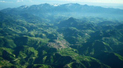 A birds-eye view of the Italian Alps, with winding mountain roads and small villages scattered throughout the region.