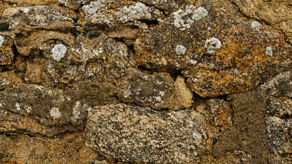 Texture of beige stone wall with rough masonry and uneven surface. Smooth, cracked surface. Old castle wall of stone different shape. Pattern with neutral colors. Minimal, stylish, trend concept.