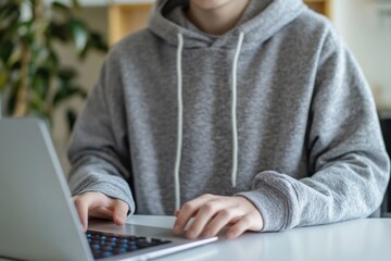 A person sitting at a table with a laptop, perfect for illustrations of work, study or online activities
