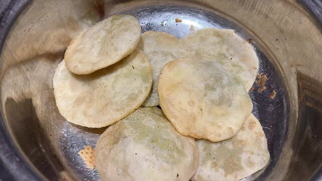 Kolkata style kachoris in steel tray to be served to guests in wedding.