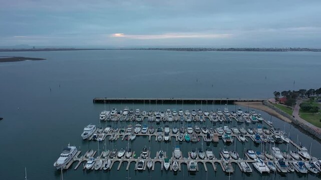 Boats docked in marina at Chula Vista harbor, San Diego California, drone backwards.