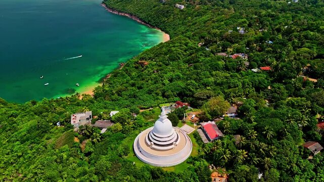 Japanese Peace Pagoda on a lush green hillside overlooking a turquoise ocean