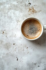 Hot coffee in a white mug on a textured background with a rich crema layer