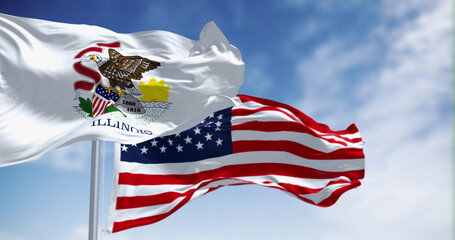 Naklejka premium Illinois and United States flags waving in the wind on a clear day