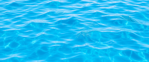 Obraz premium Clear blue water surface with sunlight reflections