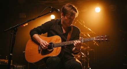 Obraz premium Talented Musician Playing Acoustic Guitar on Stage Under Warm Lights in a Captivating Live Performance Setting