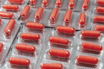 Red capsules in a silver blister packs