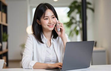 woman with medium black hair, engaged in a phone call while managing shipping schedules and inventory updates on her laptop. She’s overseeing delivery logistics for ecommerce orders