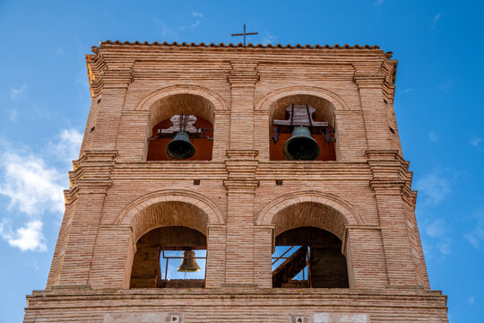 Brick bell tower with arches, large bells, and historical design