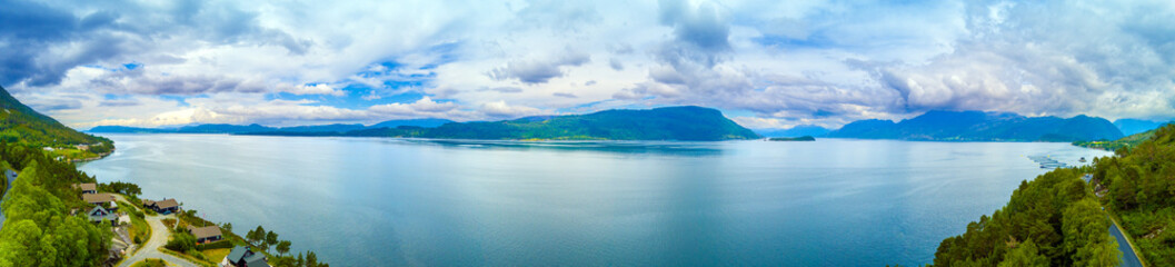Panoramic view of Kvinnherad fjord (Kvinnherasfjorden) between Lyngstranda and Enes on a cloudy day. Horizontal banner