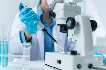 Asian Researcher using a microscope in the clinical lab.Female Researcher working in the clinical laboratory,Medical or scientific researcher or Asian woman doctor looking at professional microscope.