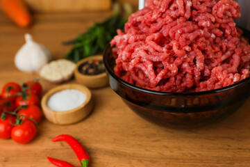 The concept of healthy eating, cooking. Close-up side view of a dark plate with red ground beef...