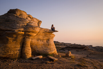 unusual alien mountain landscape. rocky seashore. man resting alone in nature