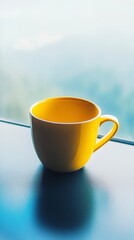 A Striking Yellow Ceramic Coffee Cup on a Blue Surface.  A Modern and Stylish Piece for Your Kitchen or Dining Area.