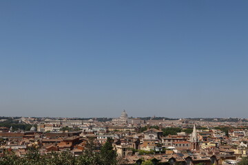Panoramic view of Rome with historic buildings, domes, and a clear blue sky, showcasing the city's architectural beauty and rich cultural heritage