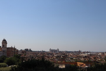 Fototapeta premium Panoramic view of Rome with historic buildings, domes, and a clear blue sky, showcasing the city's architectural beauty and rich cultural heritage