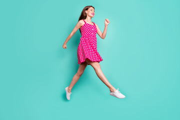 Full size photo of cute lady running wearing dotted skirt dress isolated over green teal turquoise...