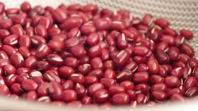 乾燥した綺麗な小豆をボウルに出す動画。クローズアップ。左から右へ。
