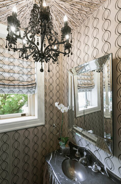 Interior view of a house, a luxurious bathroom with pattern wallpaper and chandelier