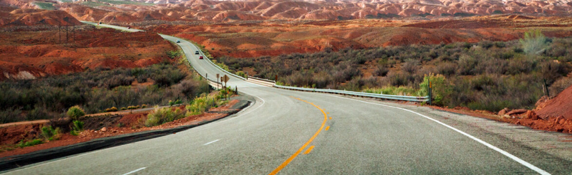 A highway going through a desert with rock formations in southern Utah
