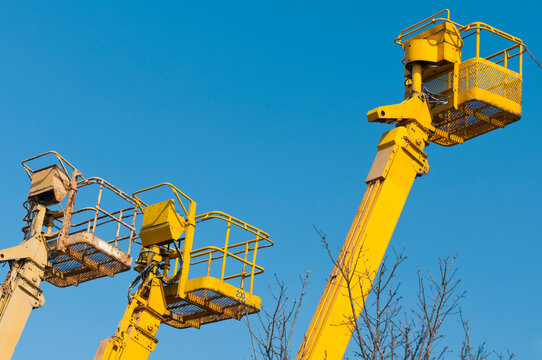 A group of mobile cranes with hooks and pulleys, dockyard lifting equipment.