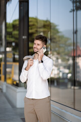 Walking young businessman commuting talk mobile phones walking to work during his morning commute in the city.