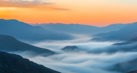 Fototapeta premium Tranquil dawn landscape, Misty valleys enveloped by majestic mountain ranges at sunrise with warm hues painting the sky above