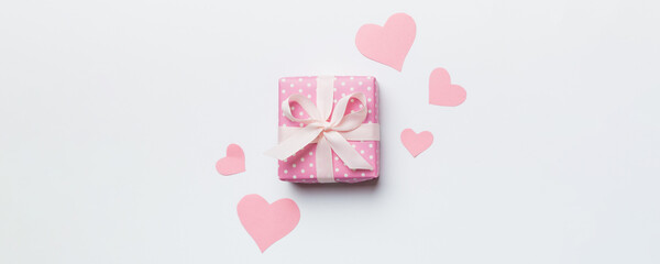 Valentine day composition Background: red gift box with bow and heart. Christmas present. View from above. Holday greeting card