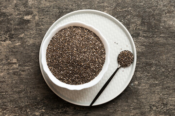 Chia seeds in bowl and spoon on colored background. Healthy Salvia hispanica in small bowl. Healthy superfood