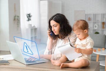 Cute little baby and young mother working with laptop while talking by mobile phone on maternity leave at home