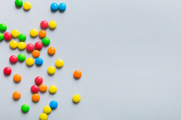 Mixed collection of colorful candy, on colored background. Flat lay, top view. frame of colorful chocolate coated candy
