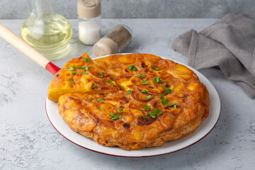 Spanish omelette with potatoes, typical spanish cuisine on gray concrete floor. Tortilla Espanola. Turkish name; Yumurtali patates