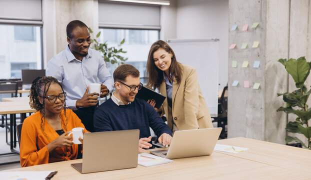 Professionals collaborating during brainstorming meeting, sharing ideas in contemporary workspace with diverse team members working together