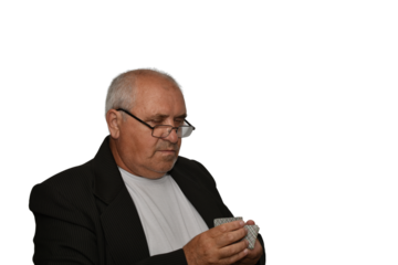 Portrait of an elderly man, side view. The man holds playing cards in his hands.