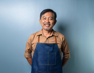 Obraz premium Asian man wearing apron and looking at camera