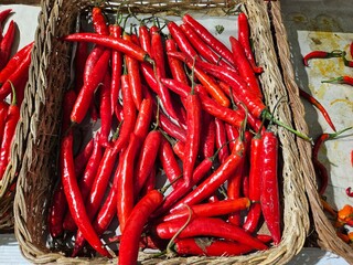 Spicy red chilies piled up in a traditional basket.