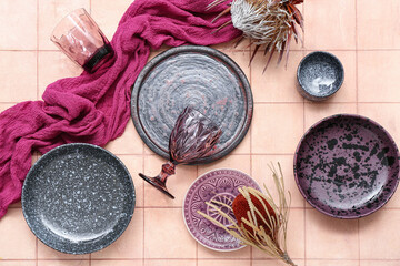 Beautiful table setting with ceramic plates and glass on beige tiled background