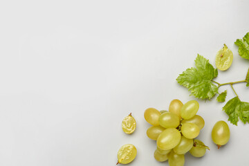 Fresh green grapes with leaves on grey background