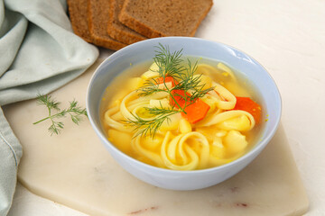 Bowl of tasty chicken soup on white background