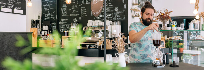 Banner of barista skillfully prepares a specialty coffee with Japanese siphon coffee maker in modern cafe setting stylish decor and cozy atmosphere, surrounded by chalkboard menus.