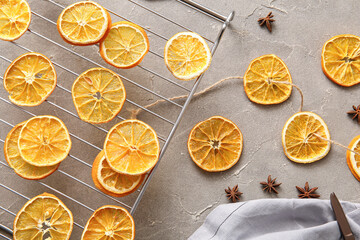Stand with dried orange slices and star anise on grey background