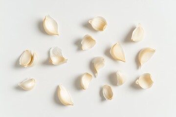 Peeled garlic cloves scattered on white background, food photography, recipe ingredient